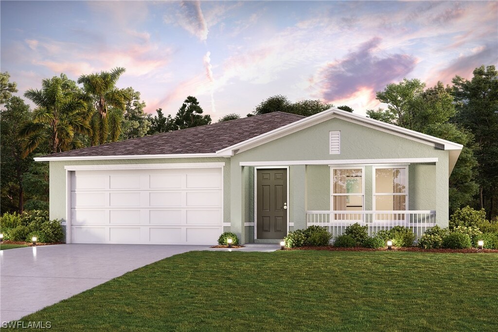 ranch-style home featuring a porch, a yard, and a garage