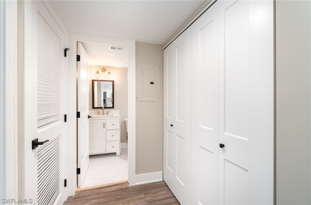 corridor with dark tile flooring and sink