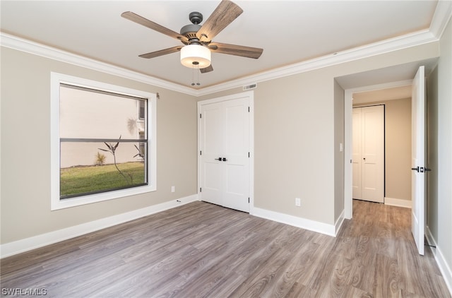 interior space with a closet, hardwood / wood-style floors, ceiling fan, and crown molding