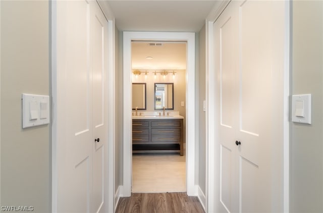 corridor featuring dark wood-type flooring and sink