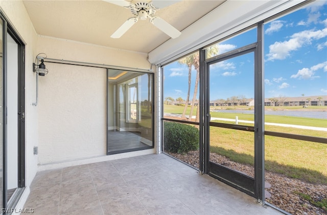 unfurnished sunroom with ceiling fan