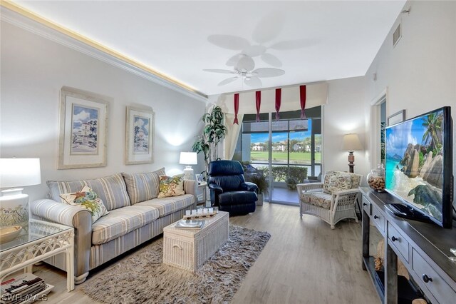 living room with crown molding, ceiling fan, and light hardwood / wood-style flooring