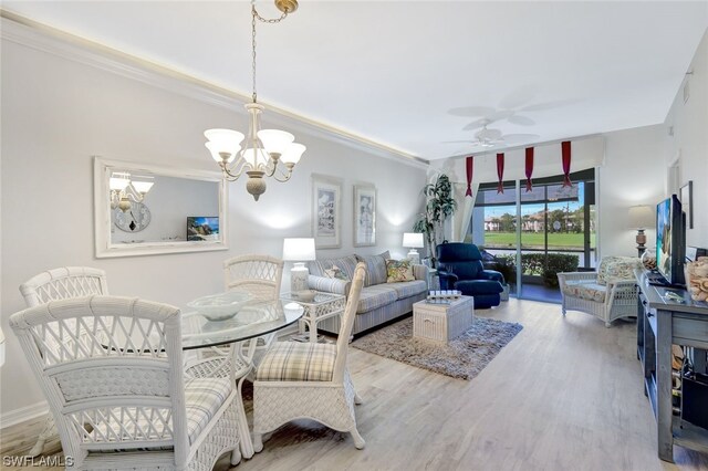 living room with crown molding, light hardwood / wood-style floors, and ceiling fan with notable chandelier