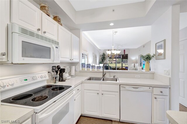 kitchen with white cabinets, white appliances, sink, and an inviting chandelier