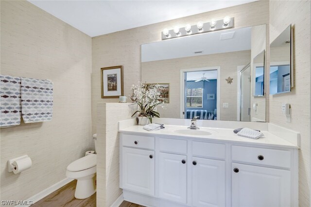 bathroom featuring hardwood / wood-style flooring, vanity, ceiling fan, and toilet