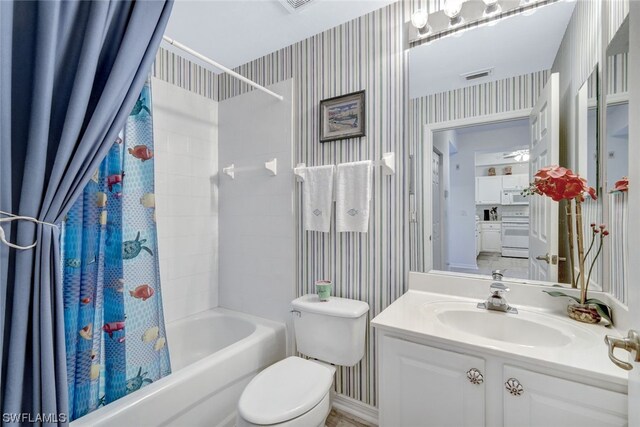 full bathroom featuring shower / bath combo, vanity with extensive cabinet space, and toilet