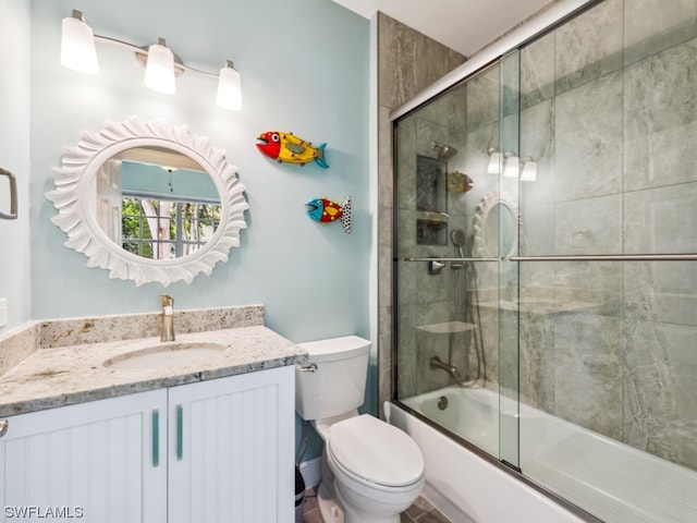 full bathroom featuring vanity, toilet, and bath / shower combo with glass door