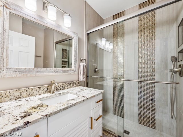 bathroom featuring vanity and a shower with shower door