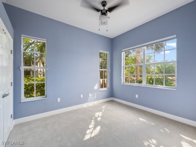 carpeted empty room with a wealth of natural light and ceiling fan