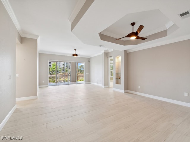 empty room with ceiling fan, a raised ceiling, light wood-type flooring, and crown molding