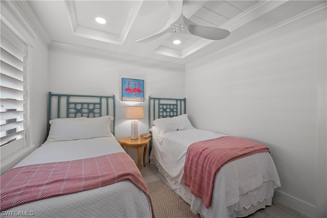 bedroom with a raised ceiling, ornamental molding, ceiling fan, and light hardwood / wood-style flooring