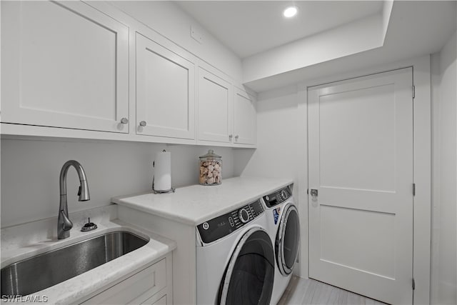 laundry area featuring washer and dryer, light tile flooring, cabinets, and sink