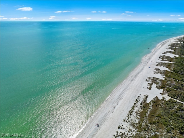 birds eye view of property with a water view and a beach view