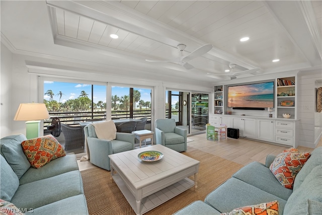 living room with built in features, ornamental molding, ceiling fan, and light wood-type flooring