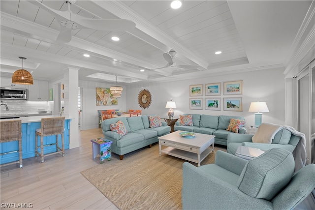 living room with light hardwood / wood-style floors, ceiling fan, and ornamental molding