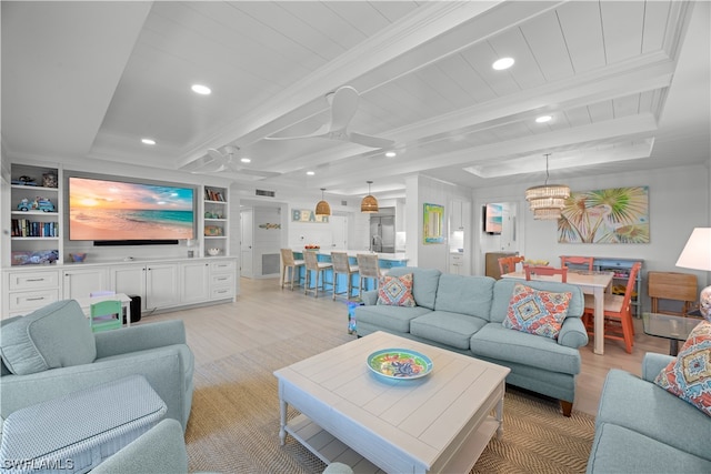 living room with built in features, light hardwood / wood-style flooring, ceiling fan with notable chandelier, and beamed ceiling