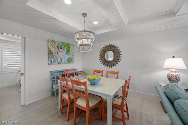 dining room with light hardwood / wood-style floors, a notable chandelier, a tray ceiling, and ornamental molding