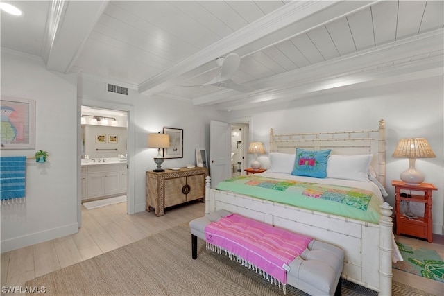 bedroom with sink, crown molding, light hardwood / wood-style floors, ensuite bath, and beam ceiling