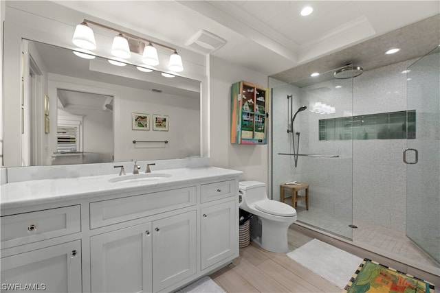 bathroom with vanity, a shower with shower door, toilet, and ornamental molding