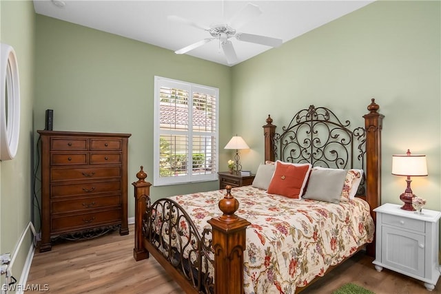 bedroom featuring ceiling fan, light hardwood / wood-style flooring, and fridge