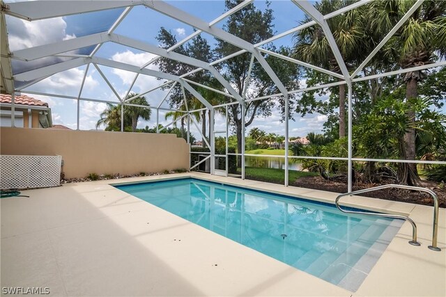 view of pool featuring a water view, a patio area, and a lanai