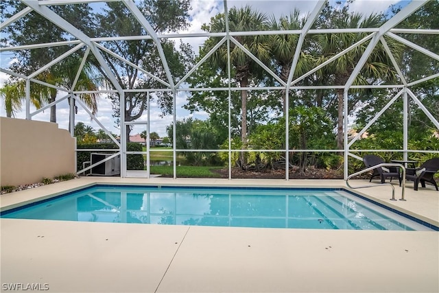 outdoor pool with a patio and glass enclosure