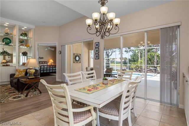 dining room featuring ceiling fan with notable chandelier and light hardwood / wood-style flooring