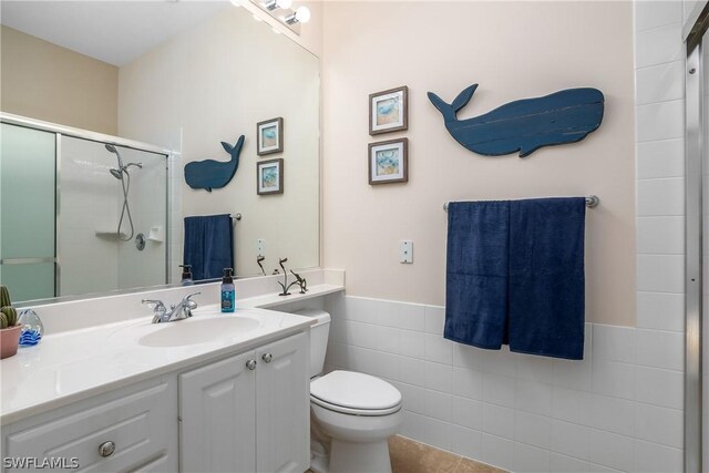 bathroom with vanity, tile patterned flooring, toilet, tile walls, and walk in shower