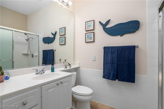 bathroom featuring a wainscoted wall, tile walls, toilet, a shower stall, and vanity