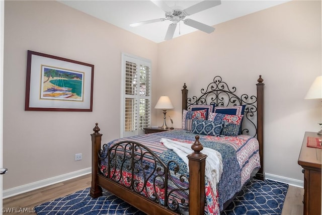 bedroom with ceiling fan, baseboards, and wood finished floors