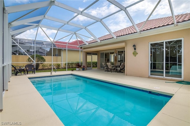 view of pool with a patio and glass enclosure