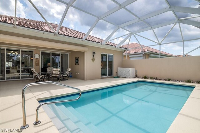 view of swimming pool with a patio and glass enclosure