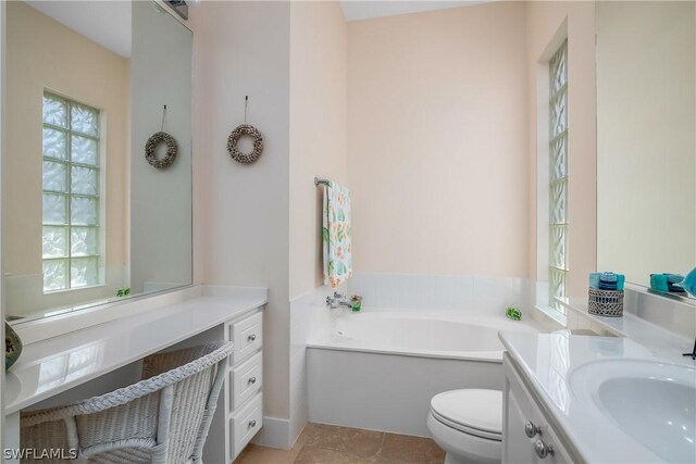 bathroom with tile patterned flooring, vanity, toilet, and a tub