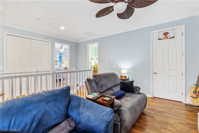 living room with wood-type flooring and ornamental molding