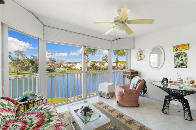 sunroom featuring ceiling fan and a water view