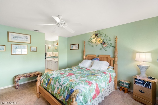 bedroom with light carpet, ensuite bathroom, and ceiling fan