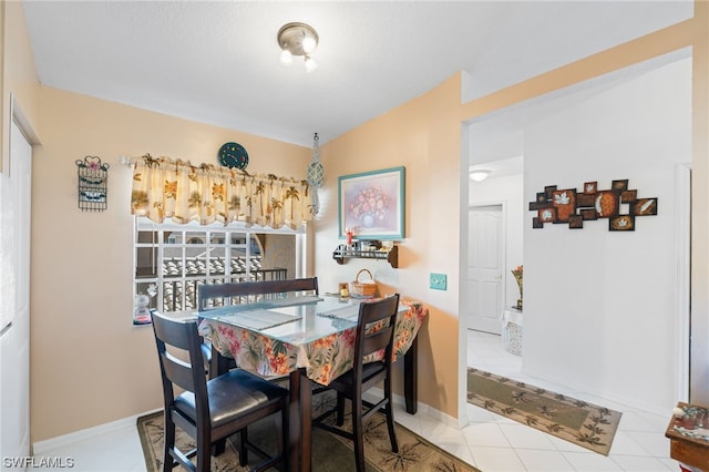 dining room with light tile floors and lofted ceiling