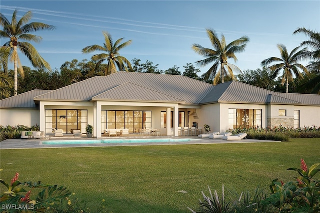 rear view of house with a lawn and a patio