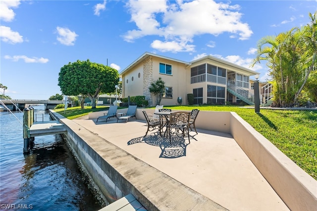 view of terrace with a dock, a water view, and a sunroom