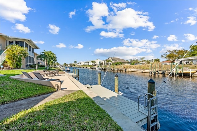 view of dock with a lawn and a water view