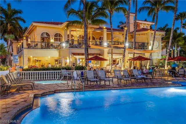 pool at twilight featuring a patio