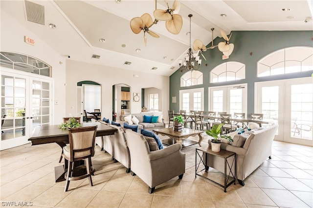 living room with a towering ceiling, french doors, light tile flooring, and a wealth of natural light