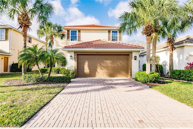 mediterranean / spanish-style home with a front yard and a garage