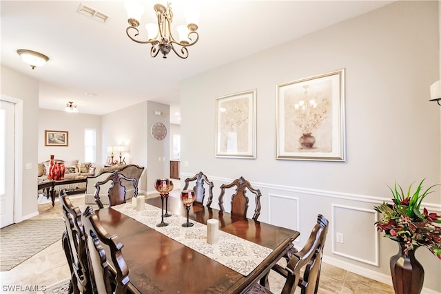 dining room with a chandelier and light tile floors