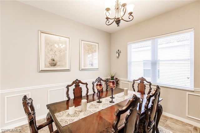 tiled dining room featuring a chandelier