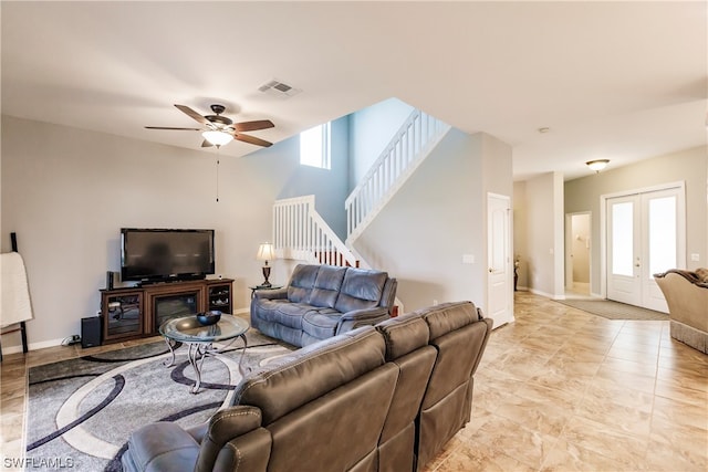 living room with plenty of natural light, light tile floors, ceiling fan, and french doors