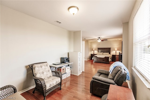 living room with ceiling fan, a healthy amount of sunlight, and light wood-type flooring