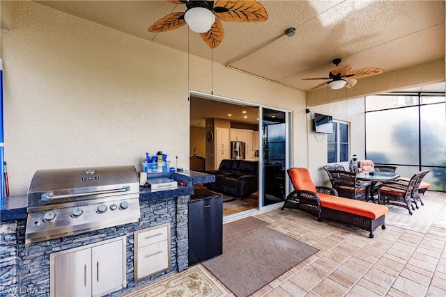 view of terrace with exterior kitchen, area for grilling, and ceiling fan