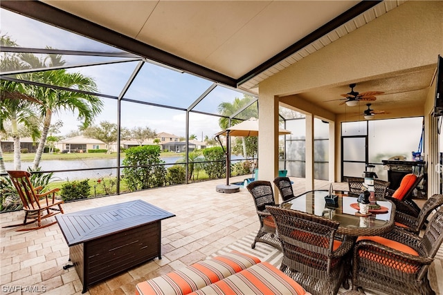 sunroom with ceiling fan and lofted ceiling with beams