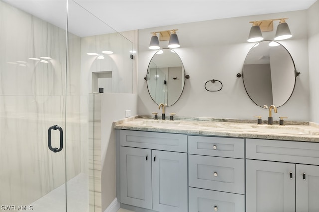 bathroom featuring a shower with door and dual vanity